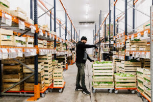 un homme dans un entrepôt rempli de produits alimentaires issus de filières en circuit coirt